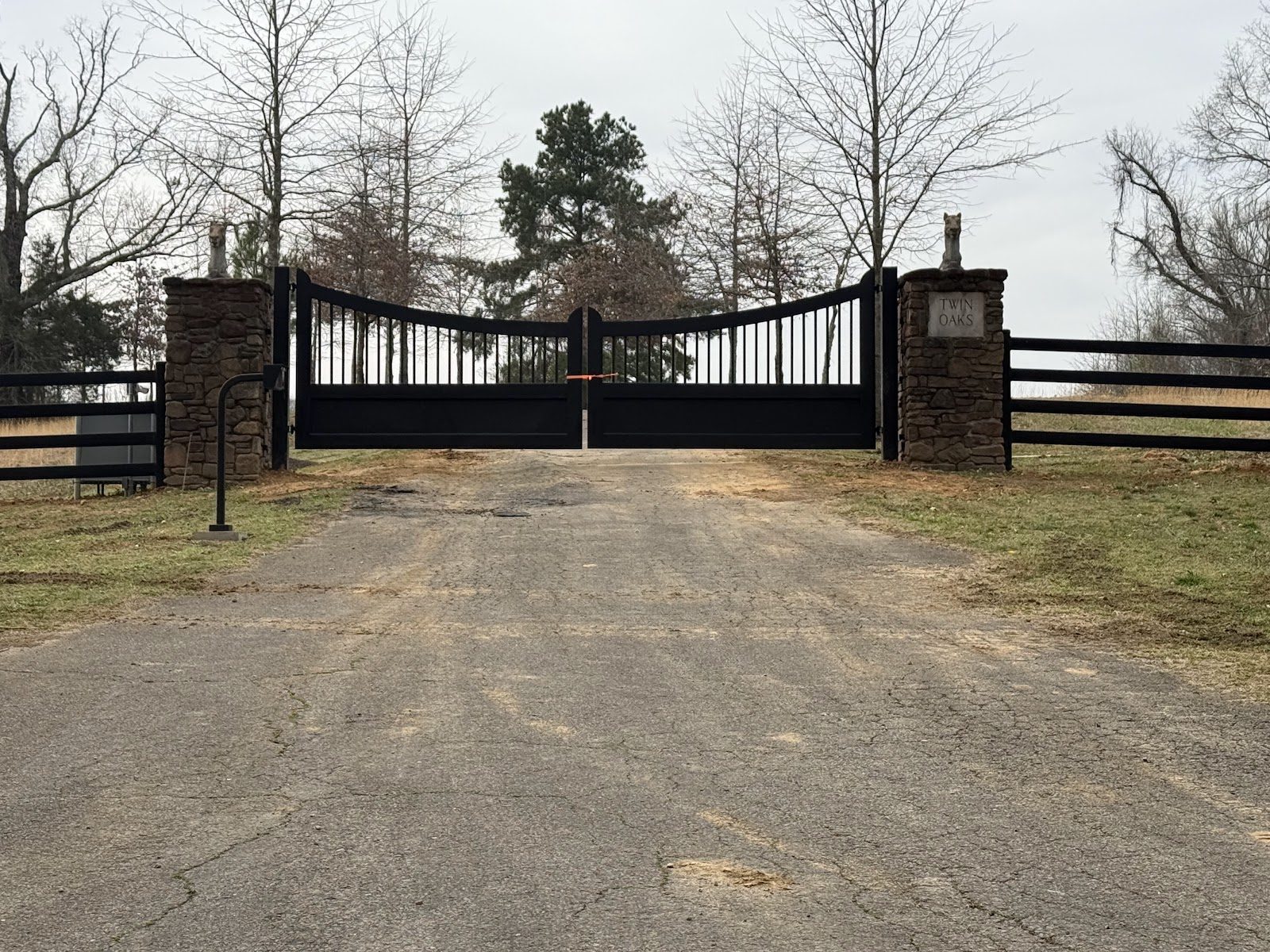 Black metal entrance gate with brick columns