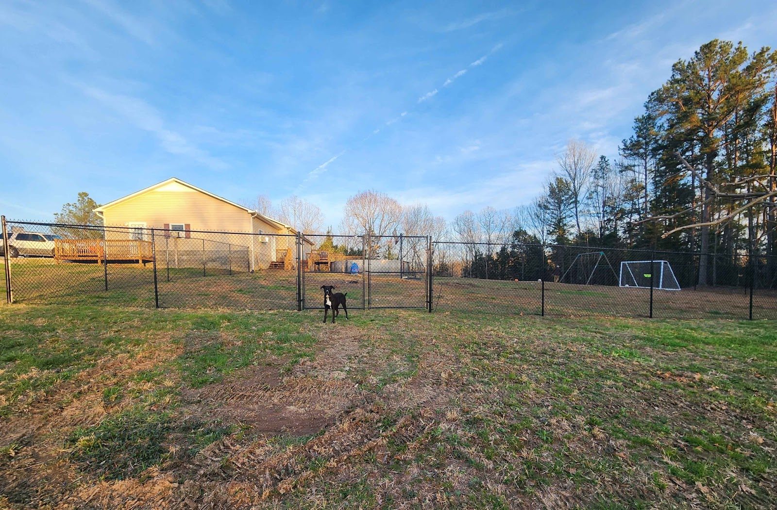 Black chain link fence around a large yard
